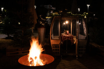 Die Wintergenussgondeln auf der Terrasse des Park Eleven sind eingebettet in einen charmanten Christbaumwald.