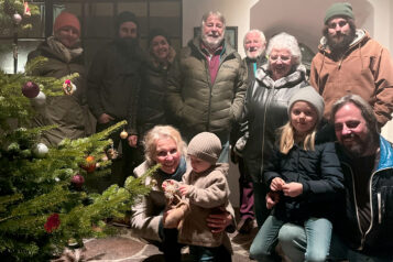 Familie Bachmann vereint vor einem festlich geschmückten Christbaum – ein Symbol für Gemeinschaft und Zusammenhalt.